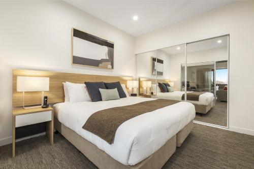 Habitación de hotel con cama grande y espejo en Quest Nowra, en Nowra