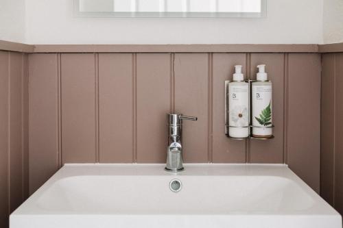 a white sink with two bottles on a wall at Fox Inn in Guisborough