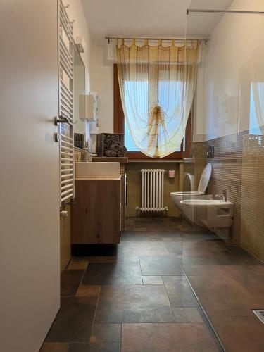 a bathroom with a sink and a toilet and a window at Giramondo in Senigallia