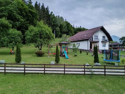 ein Haus mit einem Garten mit Spielplatz in der Unterkunft Casa Magnolia in Poiana Mărului