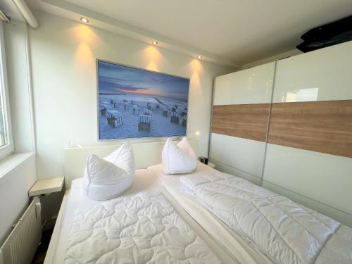 a bedroom with a bed with a painting on the wall at Panoramic App B10-7 in Sierksdorf