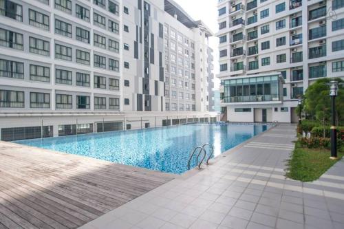 a swimming pool in the middle of two tall buildings at Modern Dpulze Soho fit 4pax,Netflix provided in Cyberjaya