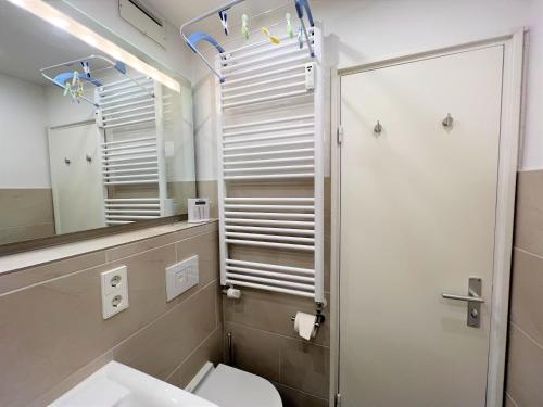 a bathroom with a toilet and a mirror at Panoramic App B10-7 in Sierksdorf