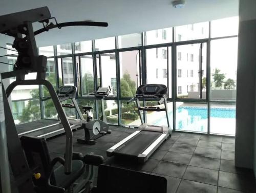 a gym with a swimming pool in a building at Modern Dpulze Soho fit 4pax,Netflix provided in Cyberjaya