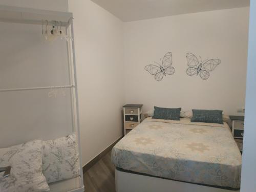 a bedroom with a bed and two butterflies on the wall at Apart Roc St Gaietà in Tarragona