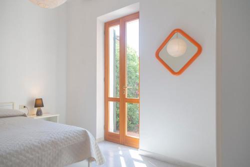 a white bedroom with a bed and a window at Casa Fetovaia - HelloElba in Fetovaia