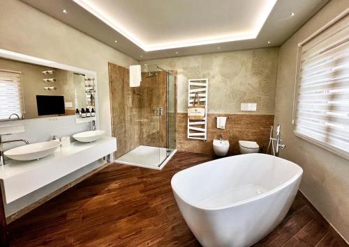 a large bathroom with two sinks and a tub at Villa Mario Resort in Salò