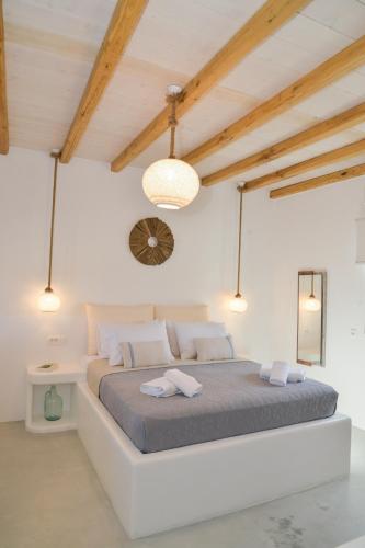 a white bedroom with a large bed in a room at Orion Milos in Pollonia