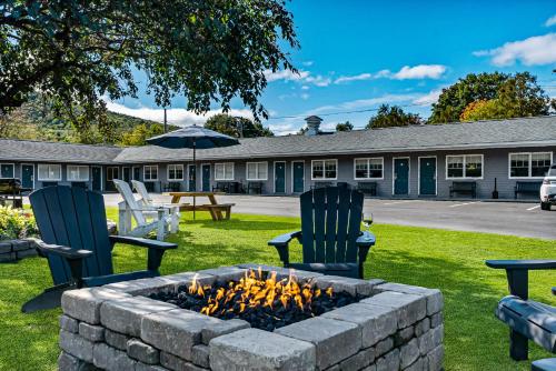 two chairs and a fire pit in front of a building at Top Notch Inn in Gorham