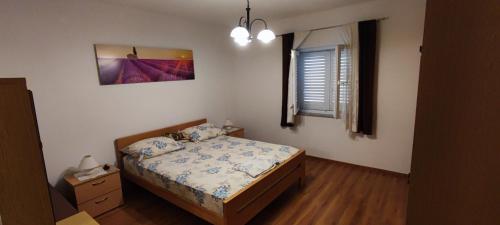 a small bedroom with a bed and a window at Apartment Biondic in Senj
