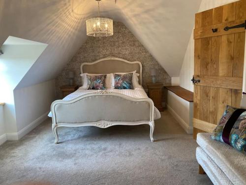 a bedroom with a white bed in a attic at Cosy luxury 3 bed cottage in The Surrey Hills in Ockley