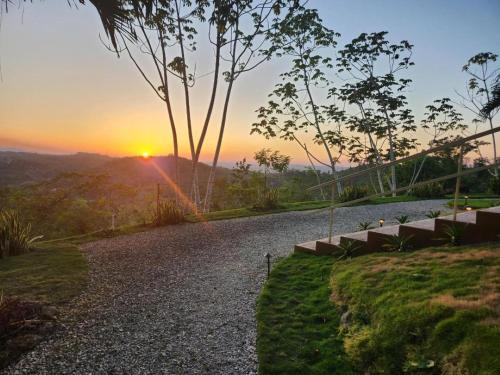 a gravel road with the sunset in the background at Villa Cayo in San Ignacio