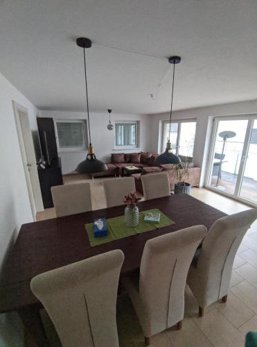 a dining room table with chairs and a living room at GrafMax Apartment in Hohenems