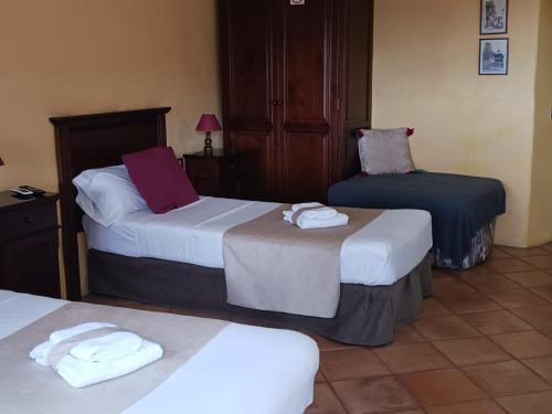 a hotel room with two beds with towels on them at Hotel Rural La Raya 1866 in Güimar