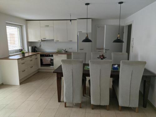 een keuken met een eettafel en stoelen bij GrafMax Apartment in Hohenems