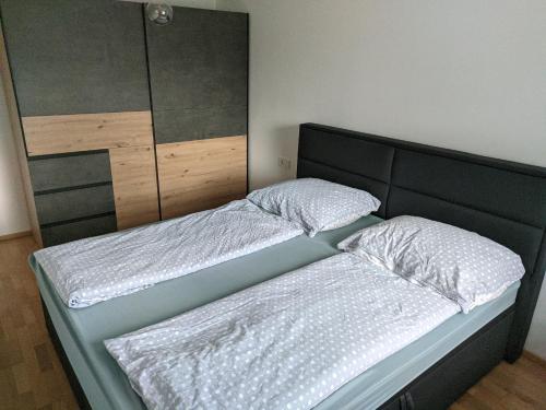 een slaapkamer met 2 aparte bedden en een hoofdeinde bij GrafMax Apartment in Hohenems