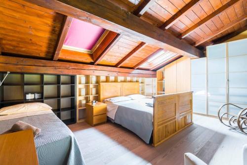 1 dormitorio con 1 cama grande y techo de madera en Ardenga Guest House, en Montechiarugolo