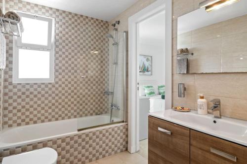 een badkamer met een bad, een wastafel en een douche bij Sea View Apartment at Wyndhams Complex in Málaga