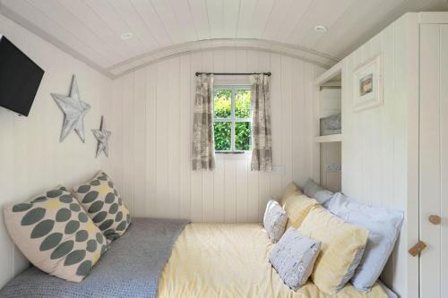 a living room with a couch and a window at Apple Blossom, Devon Hideaways in Kenton