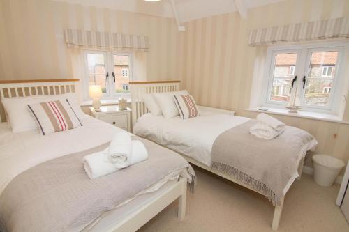 two beds in a room with two windows at Home Lea in Docking