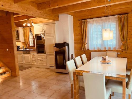 ein Esszimmer mit einem Tisch und einer Küche in der Unterkunft CHALET GAMSBOCK Koralpe in Elsenbrunn