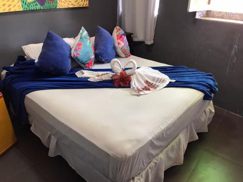 a bed with blue and white pillows on it at Pousada Alto Astral in Olinda