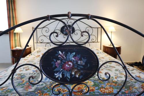 een smeedijzeren bed met een bloemenpatroon erop bij Colombo Suites in Peschici