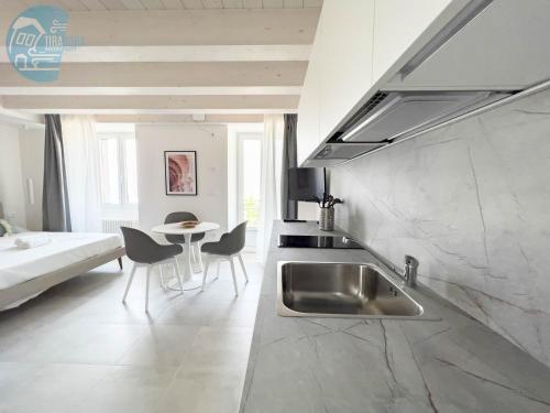 a kitchen with a sink and a table in a room at San Rocco Sweet Apartments in Muggia
