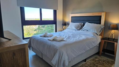 1 dormitorio con 1 cama grande y 2 toallas. en Departamento Lujoso 1 Dormitorio cerca del Shoping del Sol, en Asunción