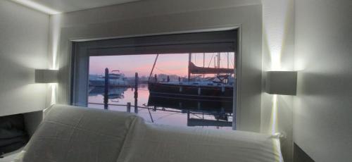 een slaapkamer met een raam met uitzicht op een boot bij Marina degli Estensi Floating Resort in Lido degli Estensi
