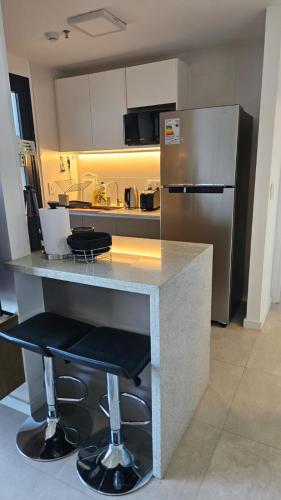 a kitchen with a counter and a stainless steel refrigerator at Departamento Lujoso 1 Dormitorio cerca del Shoping del Sol in Asuncion