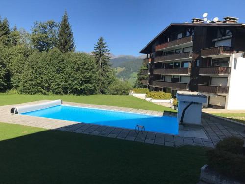 a large swimming pool in front of a building at Charming Apartment ideal for families in Megève