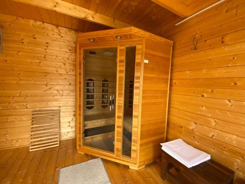 a sauna with a bench in a wooden cabin at Riviéra Apartmanok in Abádszalók