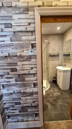 a bathroom with a wall made out of reclaimed wood at The Kimberley B&B in Blackpool