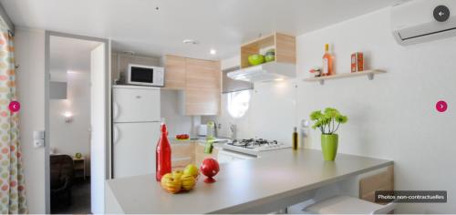 a kitchen with a counter with fruit on it at Camping Pré Vologne in Granges-sur-Vologne