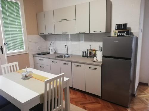 a kitchen with a stainless steel refrigerator and a table at Apartman Radanović in Foča