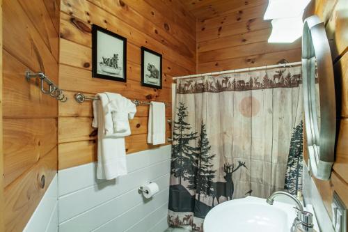 un bagno con tenda da doccia e lavandino di Laurelwood Cabin Fireflies Paradise a Cosby