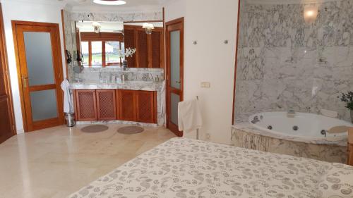 ANFI TOPAZ VILLA TAURO GOLF & BEACH 3 bedrooms 4 bathrooms private pool في موجان: حمام كبير مع حوض ومغسلة