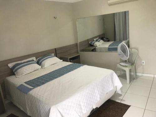 um quarto com uma cama grande e um espelho em Casa em tibau RN em Tibau