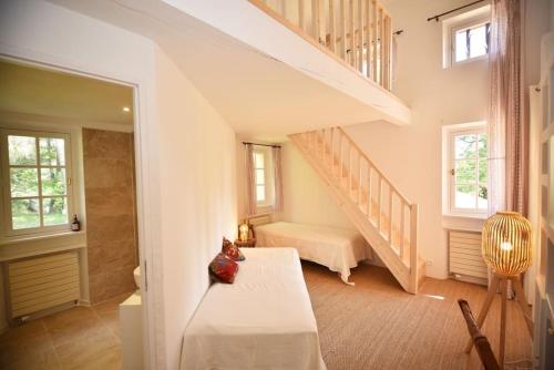 a white room with a staircase and a bed at Domaine de Matourne in Flayosc