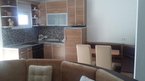 een woonkamer met een bank en een keuken bij Apartmani Kuburović 1 in Sutomore