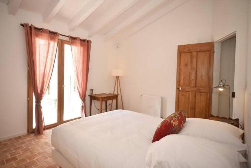 a bedroom with a white bed and a window at Domaine de Matourne in Flayosc