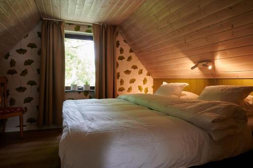 1 dormitorio con 1 cama blanca grande y ventana en Tomatlyckan 1, en Vallåkra