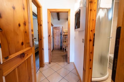 a hallway leading to the dining room and kitchen with wooden doors at Grazioso trilocale nel cuore di Folgaria in Folgaria