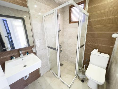 a bathroom with a shower and a sink and a toilet at Livane Sun Otel in Alanya