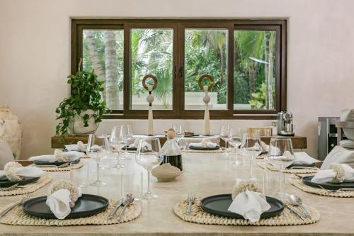 a dining room with a table with plates and glasses at 8 Bedroom Luxury Villa with Private Chef Included in Tulum