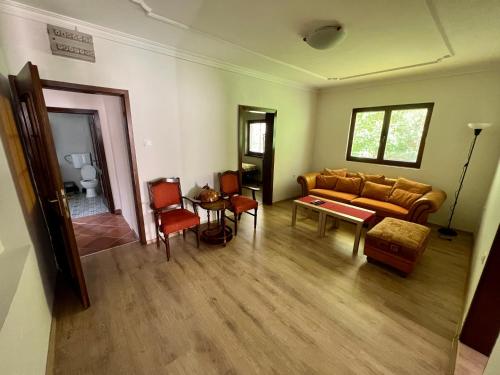 uma sala de estar com um sofá, uma mesa e cadeiras em Home Base Apartments em Skopje
