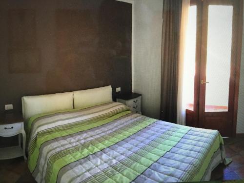 1 dormitorio con 1 cama con manta verde y azul en Residence Lentischi, en Castelsardo