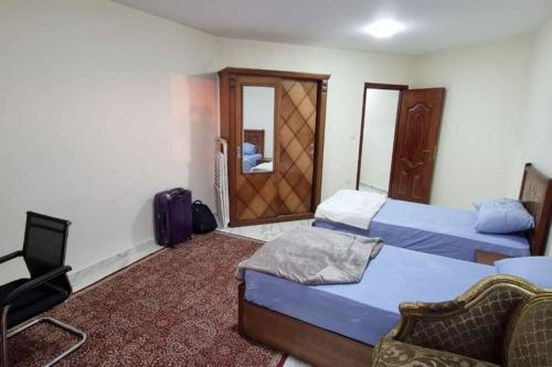 une chambre d'hôtel avec deux lits et une chaise dans l'établissement ستوديو محطة الرمل على البحر Stodeo by the Sea, à Alexandrie