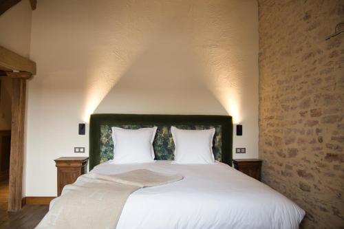 a bedroom with a large white bed with two pillows at Hostellerie De Levernois in Levernois